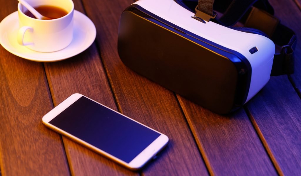 vr glasses and cell phone on wooden desk